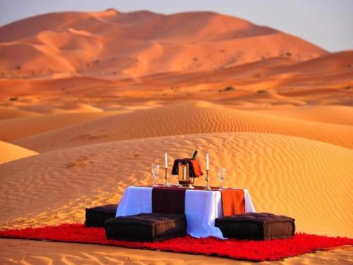 Desert Luxury Camp Experience في مرزوقة: طاوله في وسط صحراء