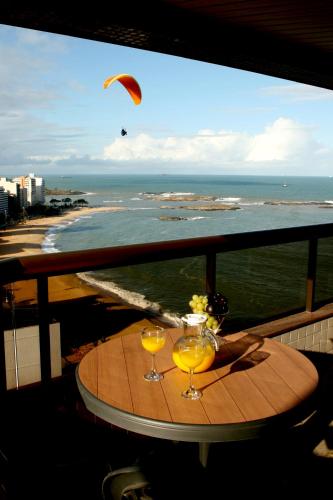 a table with two wine glasses and a view of the beach at Quality Suites Vila Velha in Vila Velha