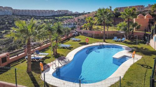 - une vue sur la piscine bordée de palmiers dans l'établissement 7 Apartment near Duquesa Port Manilva Coto Real, à Manilva