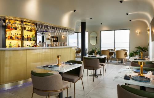 a restaurant with tables and chairs and a bar at Courtyard by Marriott London Heathrow Airport in Hillingdon