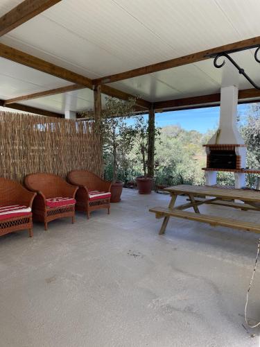 a patio with benches and a picnic table with a fireplace at MONTE DAS AREIAS CASA DE CAMPO/PASSADIÇO/PATEO/RAMPA in Porches