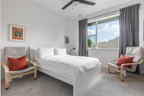 um quarto branco com uma cama e 2 cadeiras em Amazing Location Modern 2-Bed Townhome em Dallas