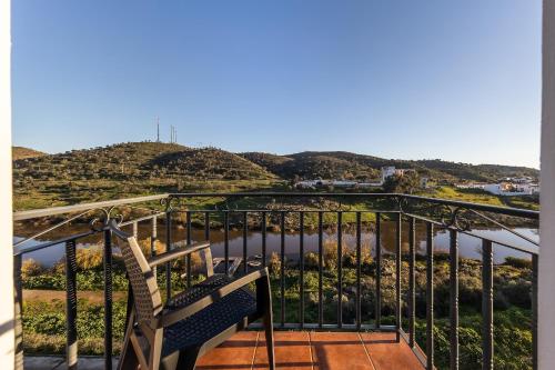 a bench on a balcony with a view of a mountain at Beira Rio in Mértola