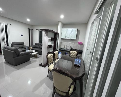uma sala de estar com uma mesa e cadeiras e um sofá em Villa Sunrise F1 em Malang