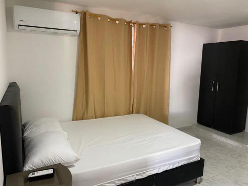 een kleine slaapkamer met een bed en een raam bij Piantini Houses in Coveñas