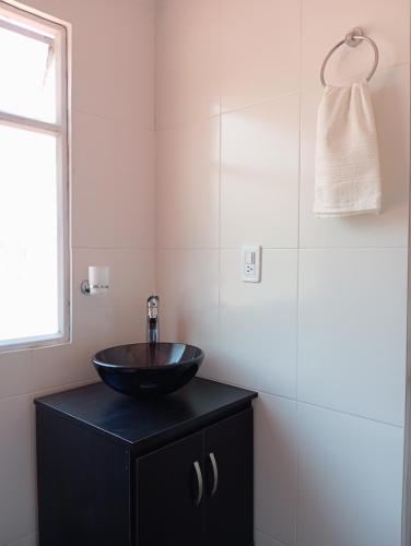 a bathroom with a black bowl sink on a black cabinet at Hospedaje Rural La Fortaleza in San Miguel