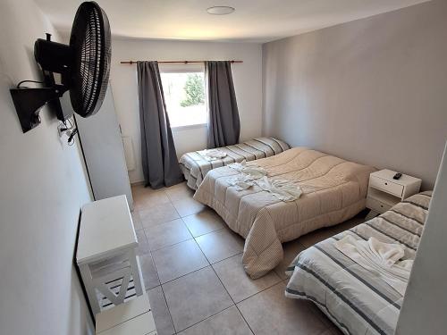 a small bedroom with two beds and a window at Hotel Los Angeles in Santa Teresita