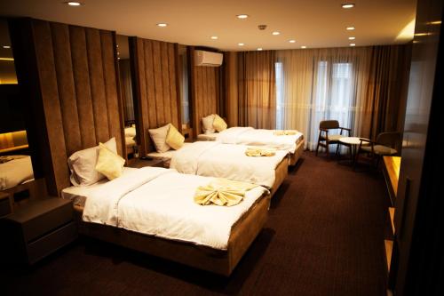 Sabiha Sultan Hotel-Karakoy في إسطنبول: غرفه بالفندق ثلاث اسره وطاولة