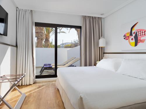 a hotel room with a bed and a large window at H10 Suites Lanzarote Gardens in Costa Teguise