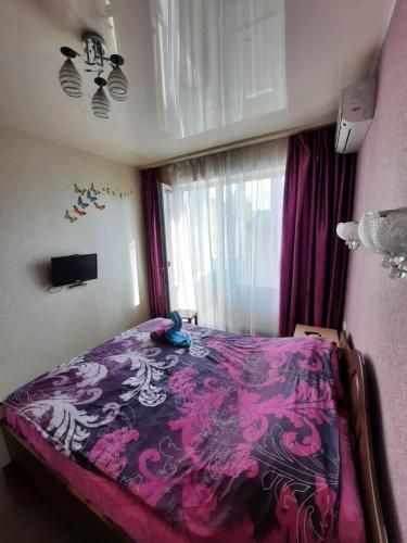 1 dormitorio con 1 cama con manta morada en Квартира возле Радмир ул.Чернивецкая 5в, en Járkov