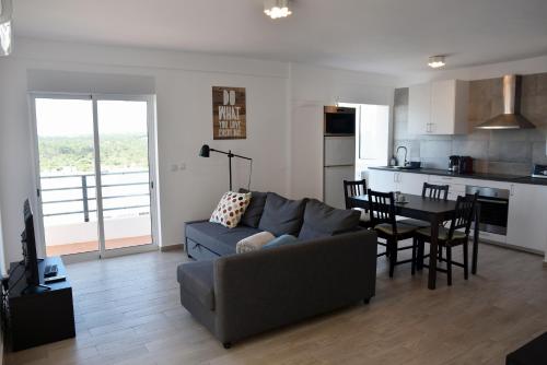 een woonkamer met een bank en een tafel bij Over the Beach in Monte Gordo