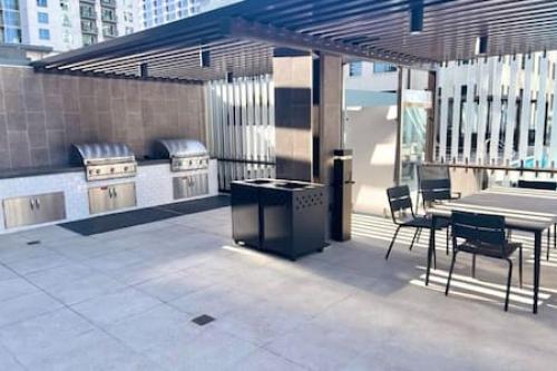 a patio with a grill and a table and chairs at Luxe 1BR plus Den near Little Italy Gem in San Diego