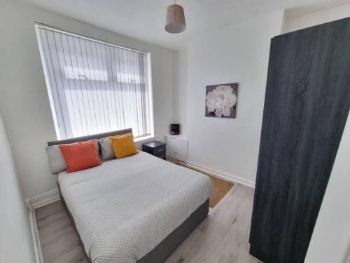 um quarto com uma cama com almofadas coloridas em Peaceful 4 Bedroom House with Free Parking em Liverpool