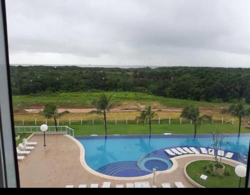 a view of a swimming pool with palm trees at SALINAS PARCK in Salinópolis
