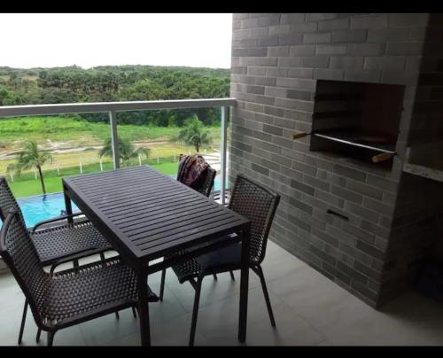 a wooden table and chairs on a balcony with a view at SALINAS PARCK in Salinópolis