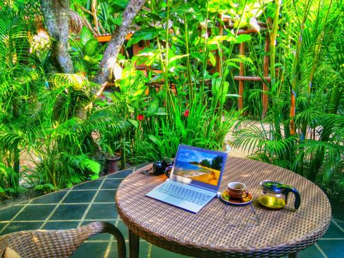 a laptop computer sitting on a table on a patio at Baanpong Lodge in San Kamphaeng
