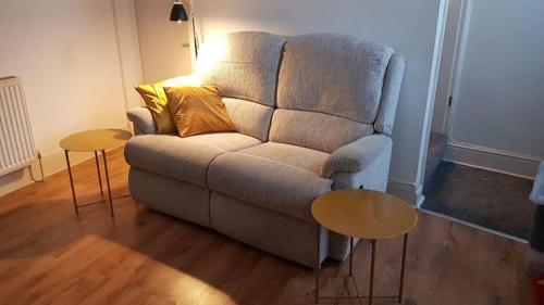 a living room with a couch and two tables at Blue Door Cottage in Meanwood