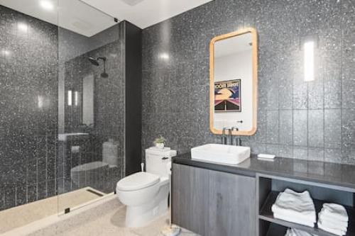 a bathroom with a toilet and a sink and a shower at 2BR Lux Highrise + Austin + Vibrant Rainey St in Austin