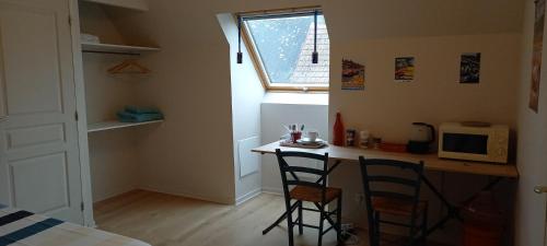 Il comprend une petite cuisine avec un bureau et deux chaises. dans l'établissement Saint Georges, à Villaines-sous-Lucé