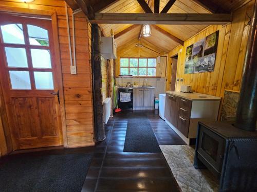 a kitchen with wooden walls and a wooden door at Vortice Chile Eco-Lodge in Manzanar