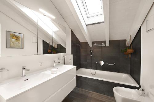 een badkamer met 2 wastafels, een bad en een douche bij Elegant Lugano Lake View - Happy Rentals in Caslano