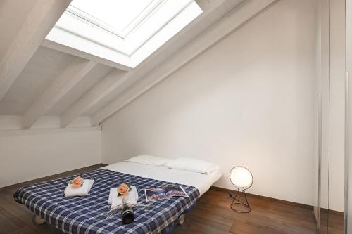 a bedroom with a bed with two towels and a skylight at Elegant Lugano Lake View - Happy Rentals in Caslano