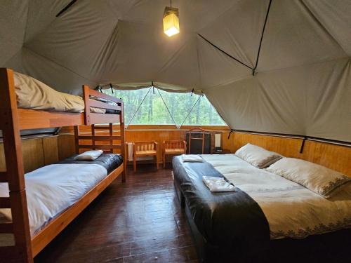 a bedroom with two beds in a tent at Vortice Chile Eco-Lodge in Manzanar