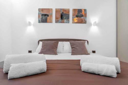 een slaapkamer met een wit bed met 2 kussens bij Sebenico 10 in Milaan