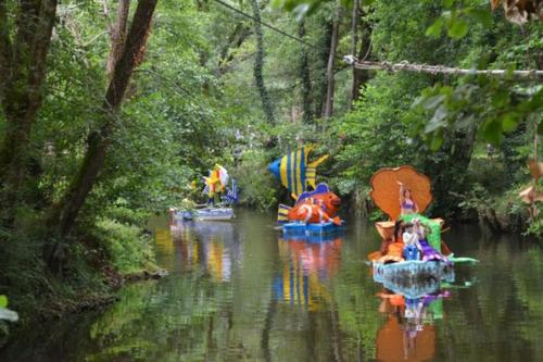 a group of boats with umbrellas on a river at Gîte Les Cerisiers Sud-Gironde dans le Sauternais meublé de tourisme 3 étoiles in Preignac