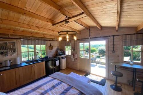 a bedroom with a kitchen and a bed in a room at Driftwood Retreat with Hot tub in Week Saint Mary