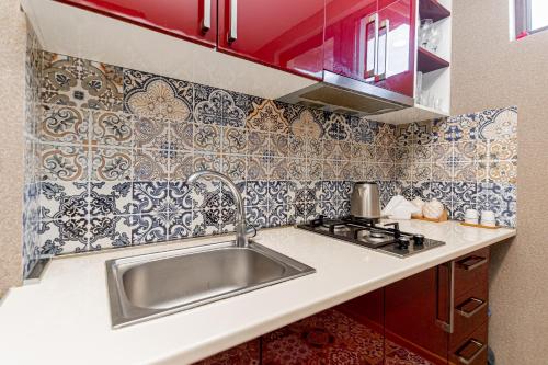 uma cozinha com um lavatório de aço inoxidável e azulejos em Apartment on Borbalo 16 em Tbilisi