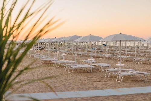 un groupe de tables et de parasols sur une plage dans l'établissement Monolocale Central - Pieno centro - Narramondo Villas, à Giulianova