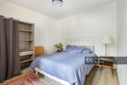 une chambre avec un lit avec un couvre-lit bleu dans l'établissement Spacious Private House 160sqm Prime Location with Yard and Parking for 2 Cars, à Saint-Ouen