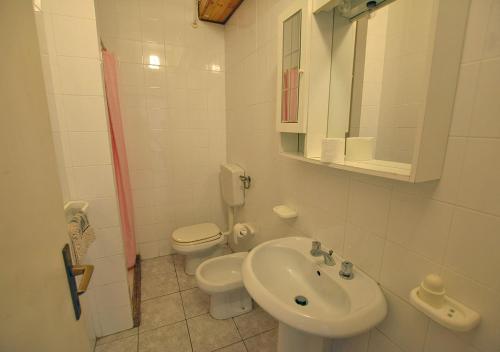 ein weißes Bad mit einem WC und einem Waschbecken in der Unterkunft CASA CECILIA in Marina di Campo