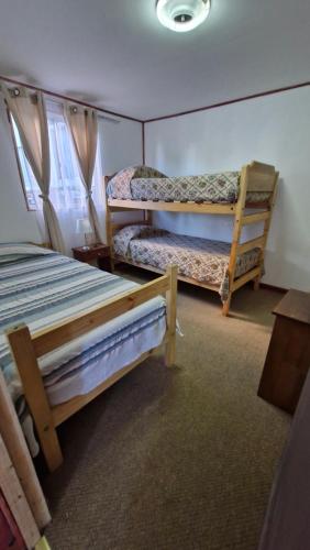 a bedroom with two bunk beds and a table at Cabaña Recreo frente al mar in Viña del Mar