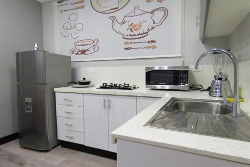 a kitchen with a sink and a refrigerator at TEYFA Hospedaje - Edificio in Atuntaqui