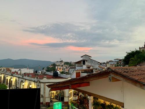 a view of a city at sunset with buildings at CasaBambu Taxco in Taxco de Alarcón