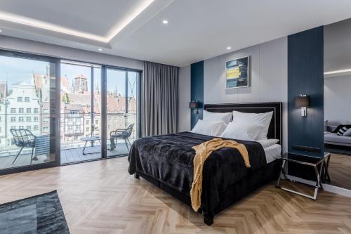a bedroom with a large bed and a balcony at Deo Plaza by Rent like home - Old Town in Gdańsk