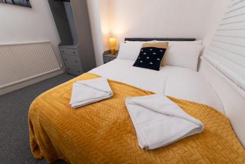 a bedroom with a white bed with two towels on it at Hampton House in Stockton-on-Tees
