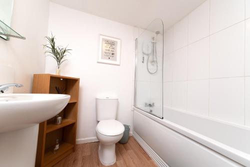 a white bathroom with a toilet and a sink at Hampton House in Stockton-on-Tees