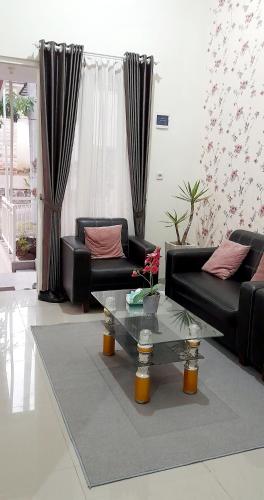 salon z czarną kanapą i szklanym stołem w obiekcie Villa Yanti F7 Permata Garden w mieście Karangploso