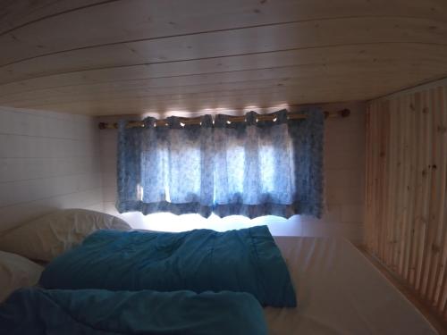 Ce lit se trouve dans un dortoir doté d'une fenêtre. dans l'établissement Camping Les Granges Bas - Mobilhomes - Tiny House, à Gérardmer