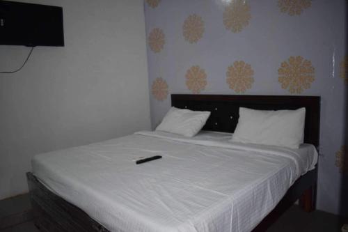 a remote control sitting on top of a bed at OYO As Hotel And Restaurant Unit 2 in Meerut