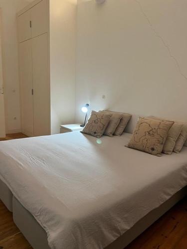 ein großes weißes Bett mit zwei Kissen darauf in der Unterkunft Quarto no Chiado centro de Lisboa in Lissabon