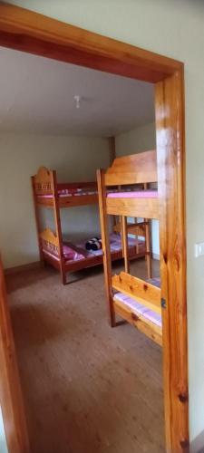 Pokój z 2 łóżkami piętrowymi i drzwiami w obiekcie Azaeleas Lodging House w mieście Sagada