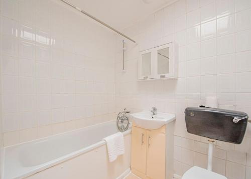 een badkamer met een wastafel, een toilet en een bad bij Superb 2 bedroom Flat in the Heart of Marylebone in Londen