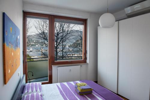 - une chambre avec un lit et une fenêtre dans l'établissement Lake Como Holiday Apartments, à Côme