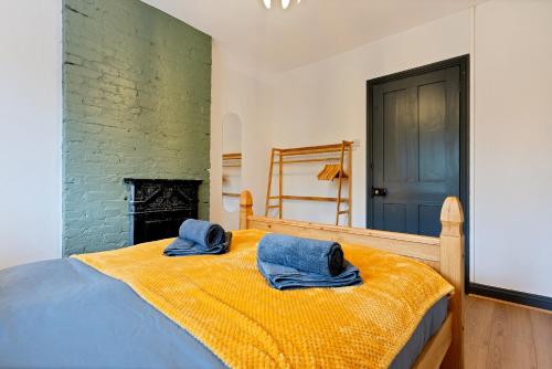um quarto com uma cama com duas toalhas azuis em Sally’s Cottage - Uttoxeter: Close to Alton Towers em Uttoxeter
