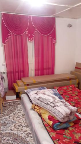 um quarto com uma cama com uma cortina roxa em Жилой дом em Aralʼsk