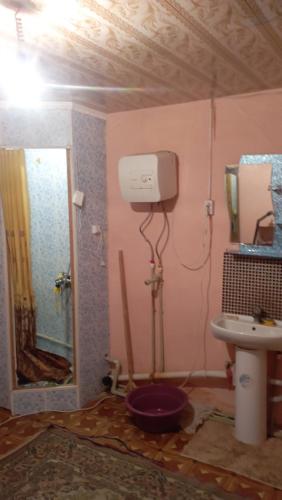 uma casa de banho com um WC, um lavatório e um espelho. em Жилой дом em Aralʼsk